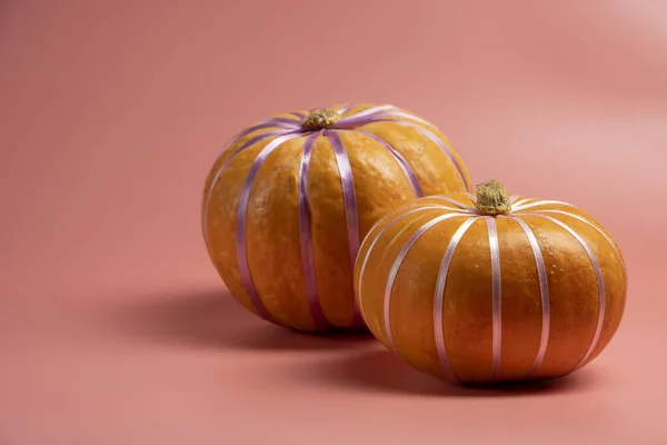 호박은 파스텔 핑크 바탕에 파스텔 리본 과 함께 있다. 가을, 가을, 할로윈 컨셉트. — 스톡 사진
