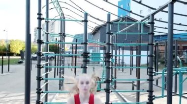 Genç sarışın seksi kadın antrenmanı, spor sahasında çömelme ve zıplama.