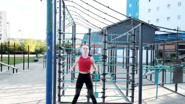 Fit jonge blonde rondborstige vrouw training, doen hurken en sprongen op sportveld — Stockvideo