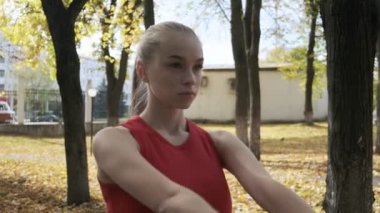 Genç beyaz göğüslü kadın omuzlarını geriyor, kollarını dışarı açıyor, kaçıyor.