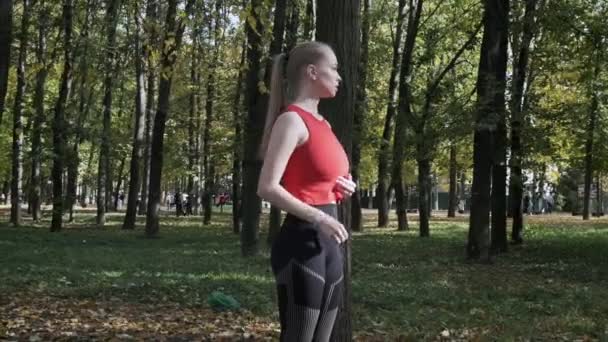 Кавказская спортсменка бегущая в спортивной одежде в осенний парк в солнечный день — стоковое видео