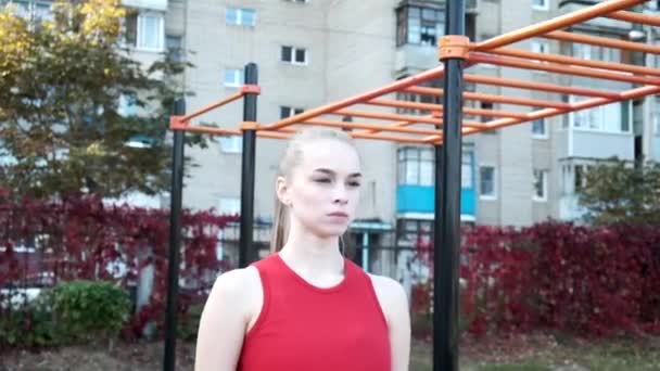 Femme caucasienne sportive se tient en position de planche pour les pompes sur le terrain de sport — Video