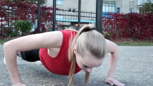 Mladé fit blondýny žena s culíkem ve sportovním oblečení pracuje na sportovním hřišti — Stock video