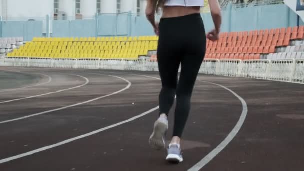 Szczupła młoda fitness ładna kobieta biegacz w odzieży sportowej działa na torze stadionu — Wideo stockowe