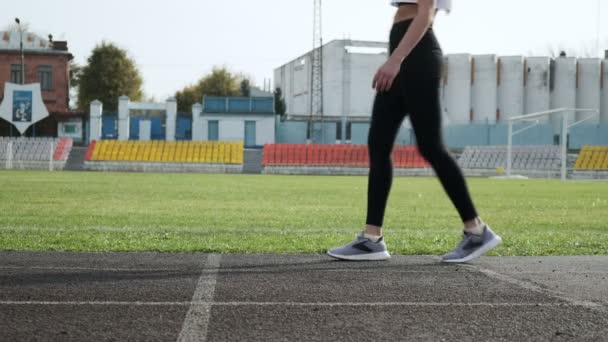 Slim fit asiático corredor en sportswear comienza a correr desde bloque en pista de estadio — Vídeos de Stock