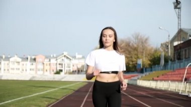Sıska, genç, sportif Asyalı spor koşucusu stadyumda koşuyor.