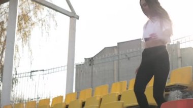 Spor giyim sektöründe genç koşucu stadyumdaki tribün merdivenlerinden inip çıkıyor.