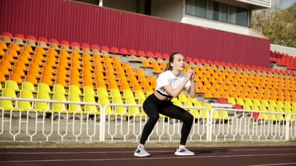 Muda kurus Asia brunette perempuan dalam pakaian olahraga melakukan olahraga latihan di stadion — Stok Video
