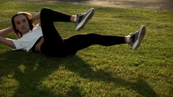 Mladý dlouhosrstý asijské fit fena dělat kolo crunches, cvičení na trávníku — Stock video