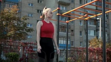 Spor giyim sektöründe genç ve formda bir kadın açık havada spor yapıyor.