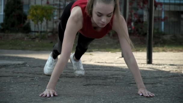 Jeune fit jolie femme en vêtements de sport fait des exercices au terrain de sport en plein air — Video