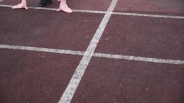 Slim Kafkas spor giyimli koşucu koşmaya başladı. Stadyum pistinde koşuyor.