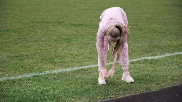 体育场足球场身穿运动服的年轻女子伸展身体 — 图库视频影像