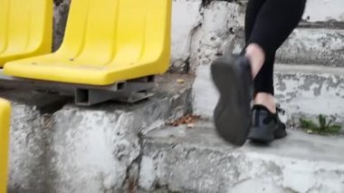 Spor giyim sektöründe genç koşucu stadyumdaki tribün merdivenlerinden inip çıkıyor.