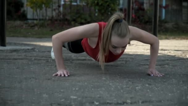 Young fit ładna kobieta w odzieży sportowej robi ćwiczenia na boisku sportowym na świeżym powietrzu — Wideo stockowe
