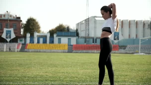 Wanita cantik Asia fit muda bersiap-siap untuk menjalankan di stadion, memperbaiki rambut panjangnya — Stok Video
