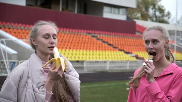 Duas irmãs gêmeas idênticas em sportswear rosa no estádio após o treinamento de fitness — Vídeo de Stock