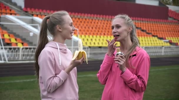 Deux sœurs jumelles identiques en tenue de sport rose au stade après l'entraînement de fitness — Video