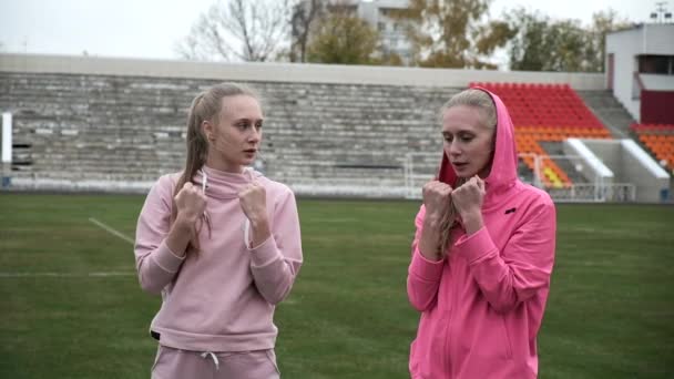 Jeune ajustement sportif caucasien jolie jumelles boxe en plein air au stade terrain — Video