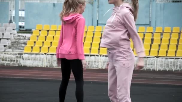 Caucasien identiques jolis jumeaux en vêtements de sport faire squats et sauts au stade — Video