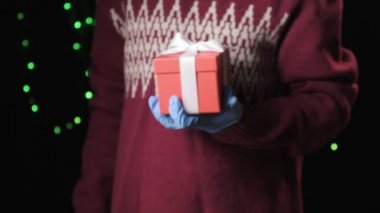 Küçük kızlar mavi koruyucu eldivenleri teslim edip beyaz kurdeleli hediye kutusunu veriyorlar.