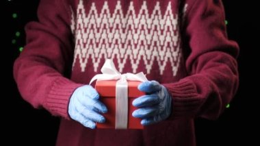 Childs 'ın elleri beyaz kurdeleli kırmızı kutuyu veriyor. Noel, yeni yıl konsepti