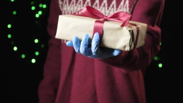 A gyerekek keze piros dobozt ad fehér szalaggal. karácsony, újév koncepció — Stock videók