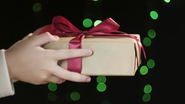 Persons hands giving christmas or birthday gift box with red ribbon to man — Stock Video