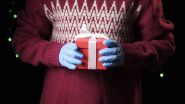 Παιδικά χέρια δίνοντας κόκκινο κουτί με λευκή κορδέλα. Χριστούγεννα, το νέο έτος έννοια — Αρχείο Βίντεο