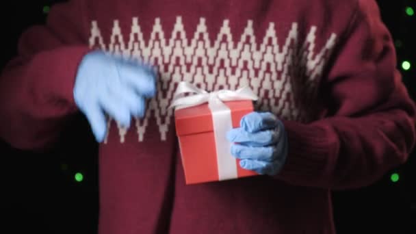 Niñas manos en guantes protectores azules dando caja de regalo con cinta blanca — Vídeo de stock