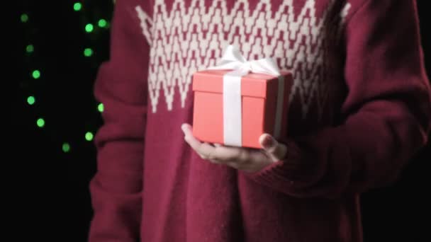 붉은 상자를 리본으로 들고 있는 냉각기를 손에 감는다. 크리스마스, 새해 컨셉트 — 비디오