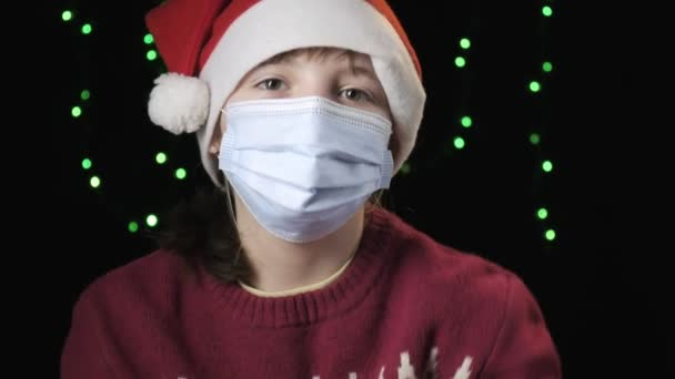 Meisje in de kerstman hoed, beschermend masker, handschoenen. Nieuwjaar, kerst quarantaine — Stockvideo