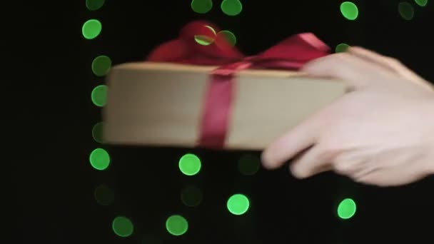 Особи руки дарують різдвяну або день народження подарункову коробку з червоною стрічкою дівчині — стокове відео