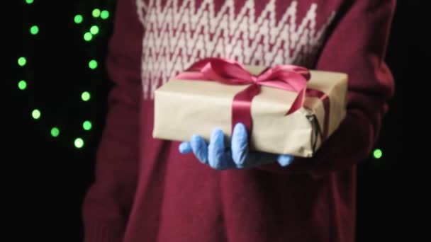Рука ребенка дарит красную коробку с белой лентой. Рождество, новогодняя концепция — стоковое видео
