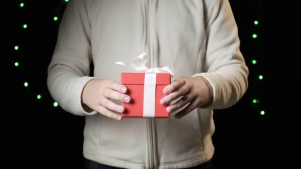 Childs hands giving red box with white ribbon. christmas, new year concept — Stock Video