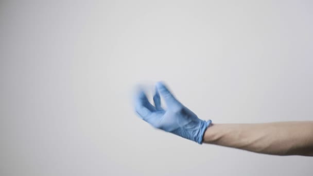 Händer i blå skyddshandskar ger presentförpackning till person. COVID-19 jul — Stockvideo