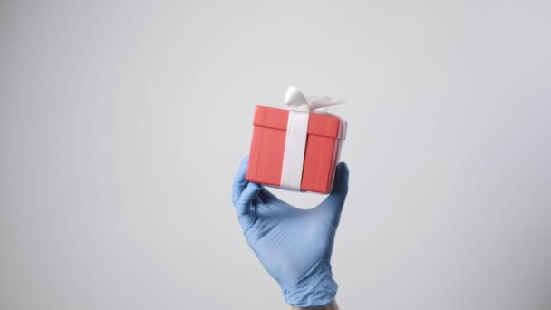 Closeup Στο Χέρι Μπλε Προστατευτικό Γάντι Κρατώντας Κόκκινο Κουτί Δώρου — Αρχείο Βίντεο