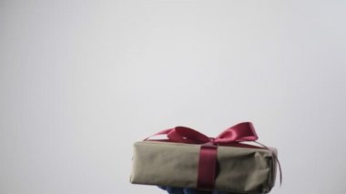 Mavi koruyucu eldivenli el, kurdeleli hediye kutusu verir. COVID-19 Noeli