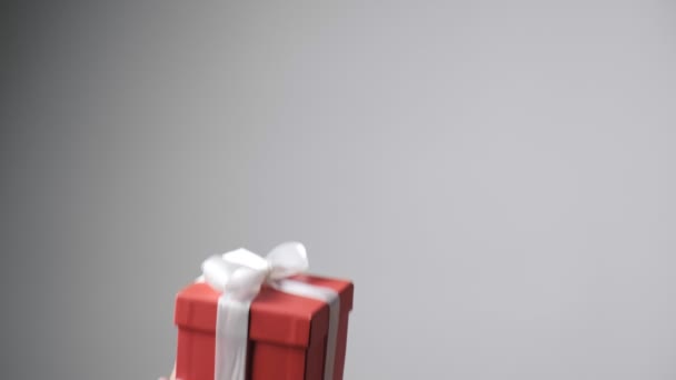 Dzieci ręce dając czerwone pudełko z białą wstążką. Boże Narodzenie, niespodzianka noworoczna — Wideo stockowe