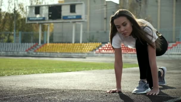 스 포오 츠 맹세를 한 날씬 한 아시아 선수가 달릴 준비를 한다. 경기장 트랙에서 달리기 — 비디오