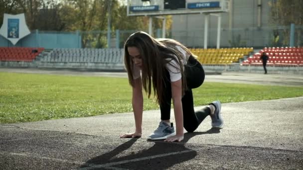 Arrabbiato fit corridore asiatico in abbigliamento sportivo si prepara a correre. sprint sulla pista dello stadio — Video Stock