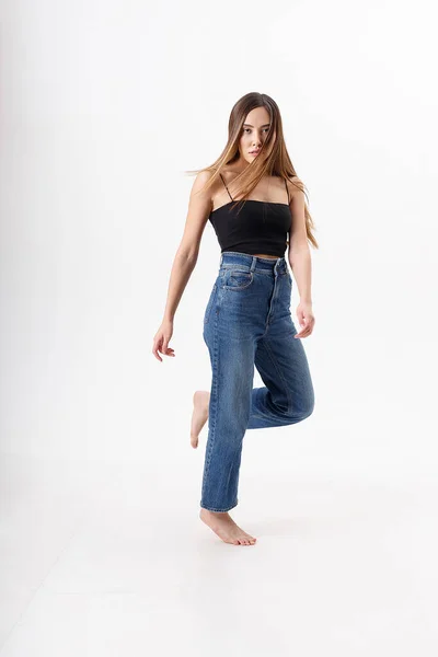 Jong aantrekkelijk aziatisch vrouw met lang haar in zwart top, blauw jeans op wit — Stockfoto