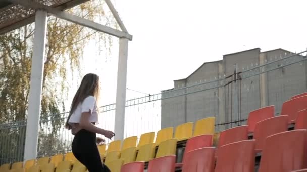 Ung løber i sportstøj løber op og ned ad stigen af tribune på stadion – Stock-video
