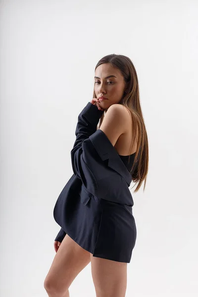 Jeune attrayant asiatique femme en noir bodysuit et bleu costume isolé sur blanc — Photo