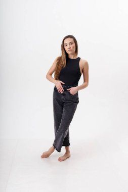 Beyaz arka planda siyah elbiseli, uzun saçlı, genç, çekici Asyalı kadın.