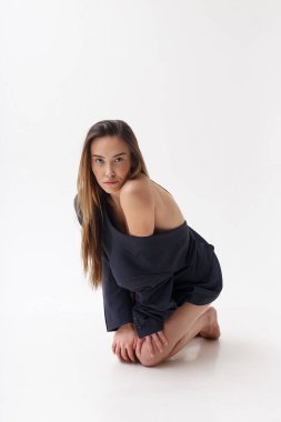 Mavi takım elbiseli genç çekici Asyalı kadın beyaz stüdyo arka planında izole edilmiş.