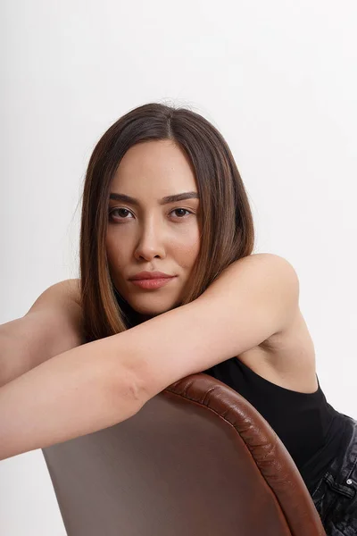 Retrato de joven atractivo asiático mujer con largo pelo marrón sentado en silla —  Fotos de Stock