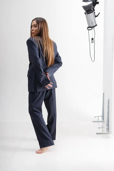 Jeune femme asiatique avec les cheveux longs en costume bleu devant l'équipement de studio — Photo