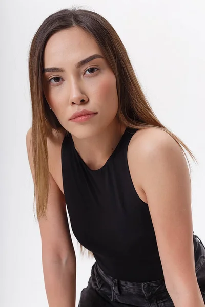 Porträtt av ung attraktiv asiatisk kvinna med långt mörkt hår i svarta kläder — Stockfoto