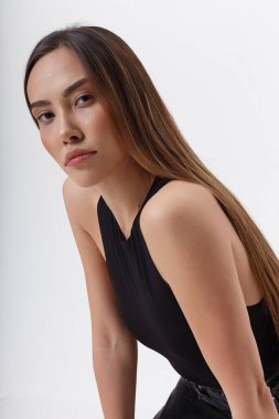 Siyah elbiseli, uzun siyah saçlı, çekici Asyalı kadının portresi.